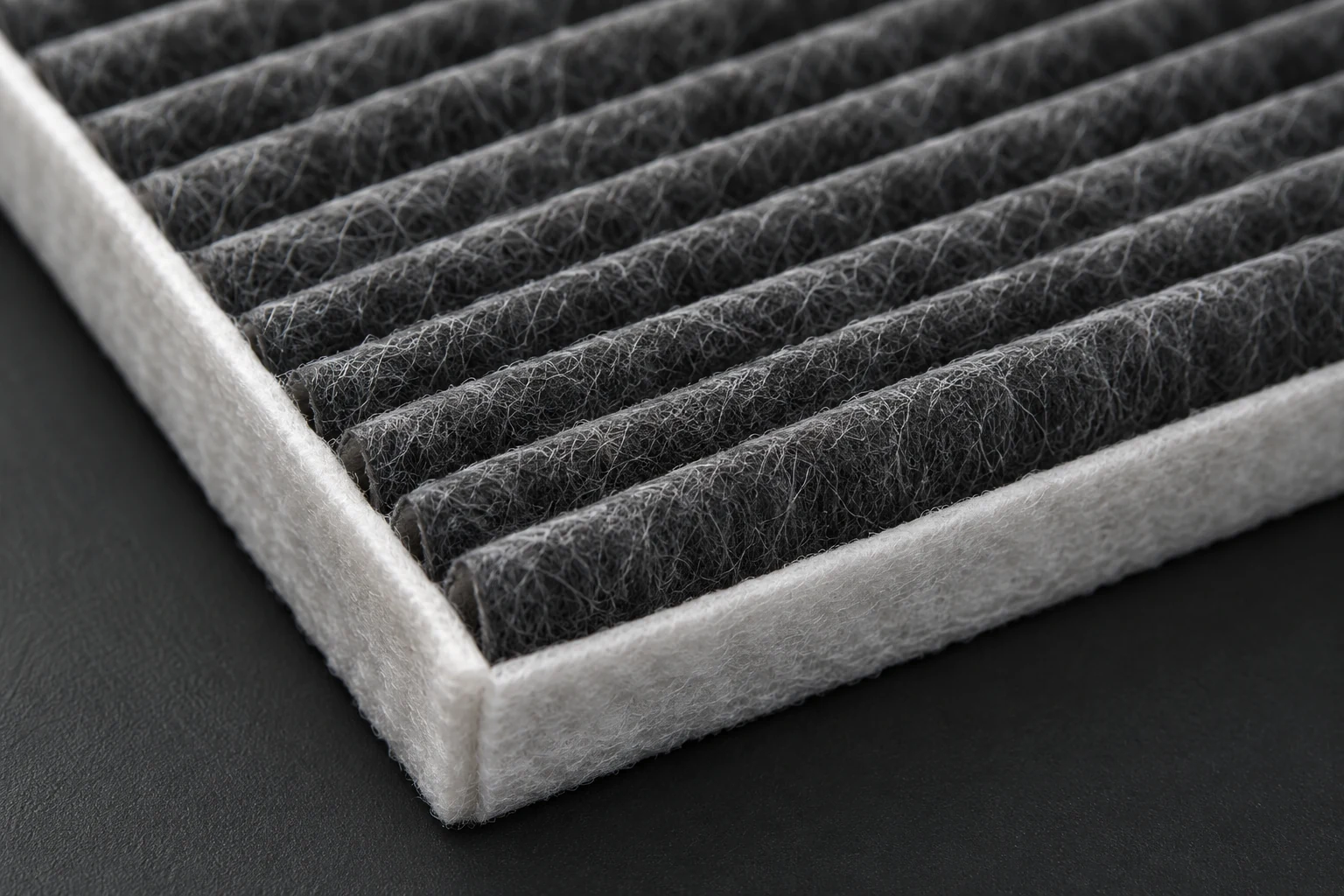 Illustrative macro view of pleated cabin filter media and edge construction